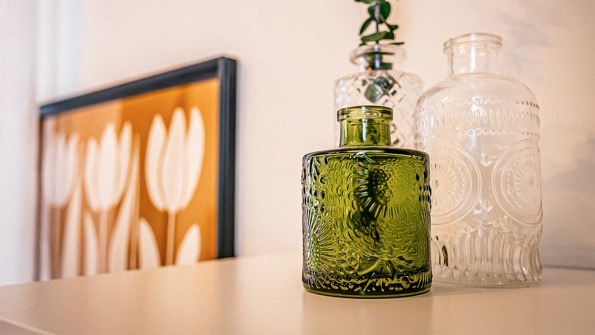 a green glass bottle on a table