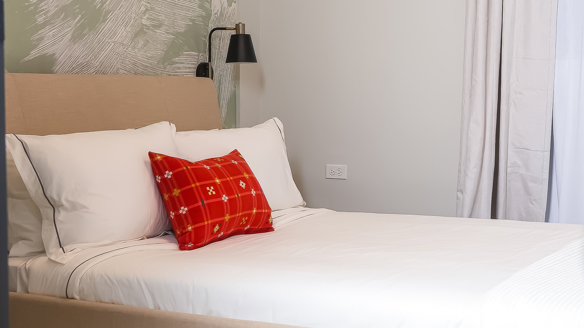 a bed with a red pillow