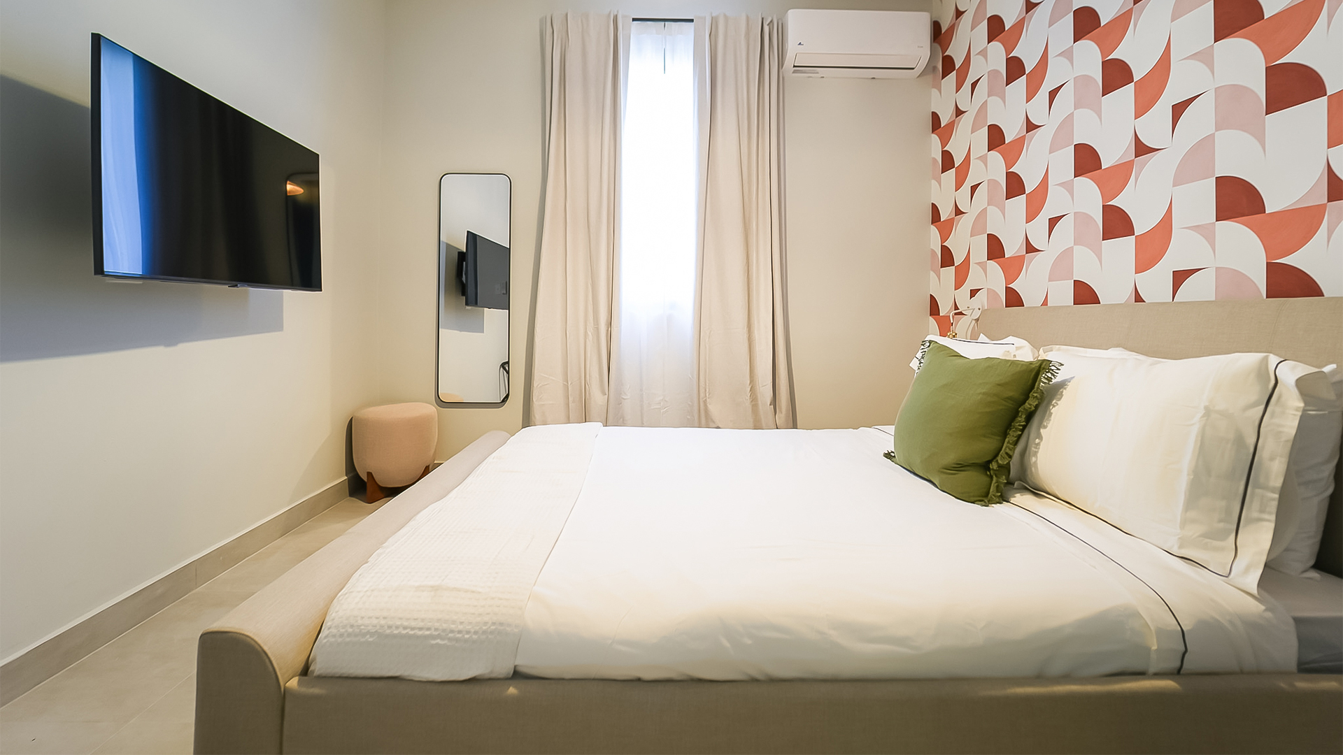 a bed with a white bed frame and a green pillow