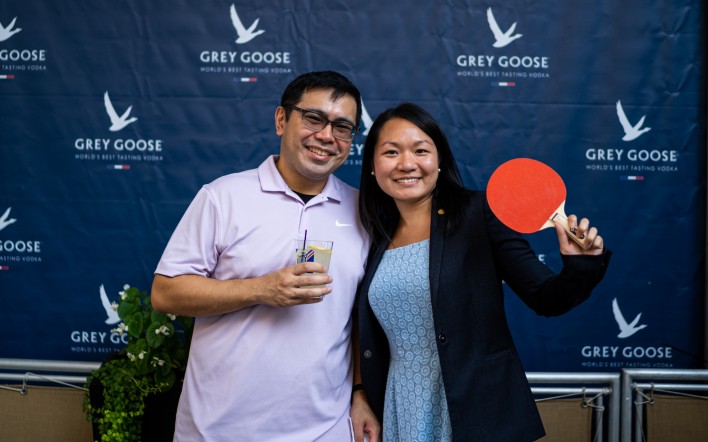 a man and woman holding a paddle and a drink