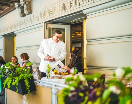 a man in a white coat smiling at a woman
