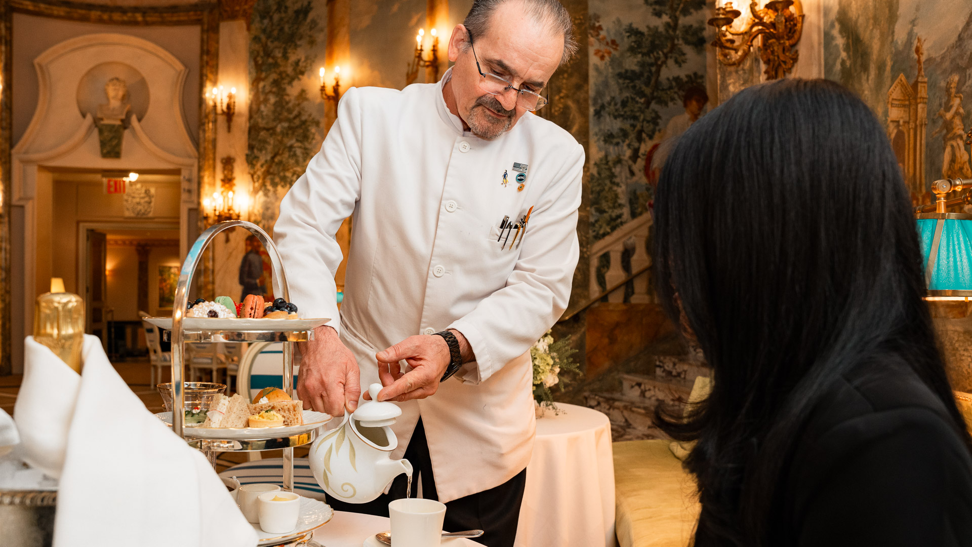 a man pouring tea into a teapot