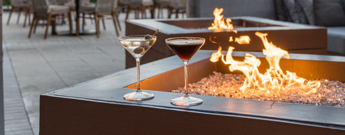 a couple of martini glasses on a fire pit