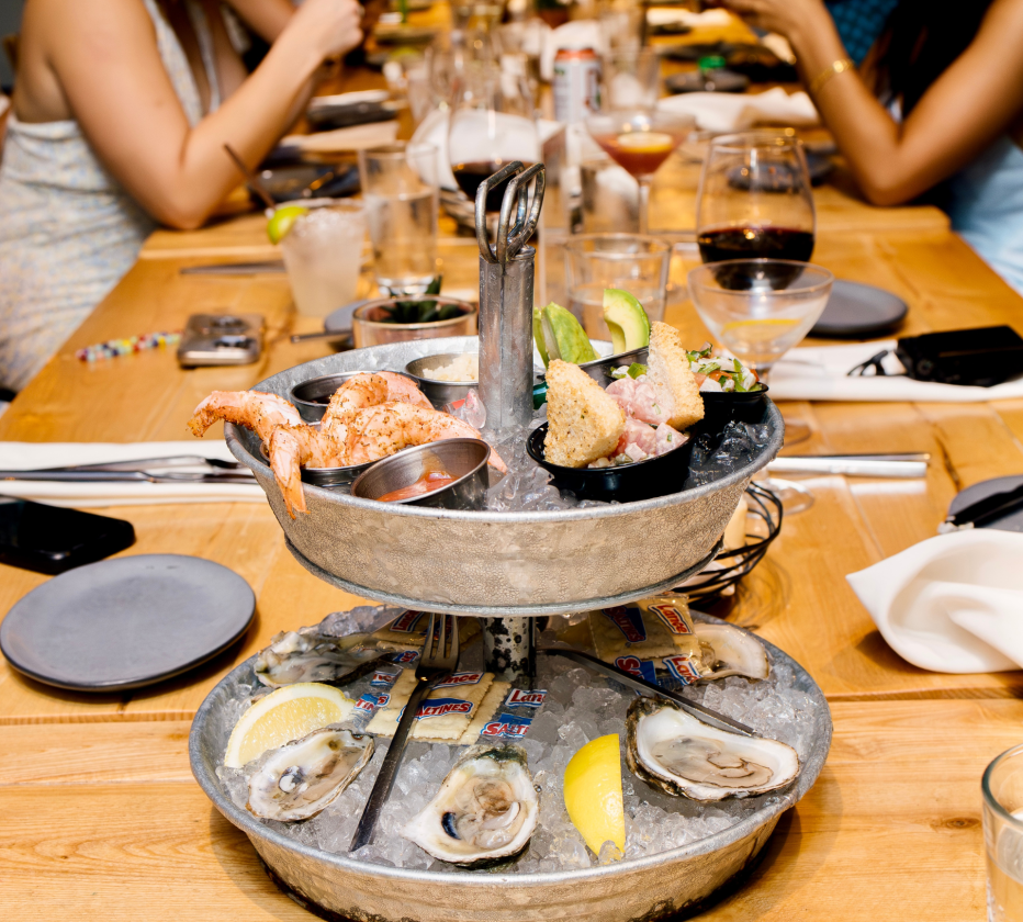 a group of people sitting at a table with food on a tray