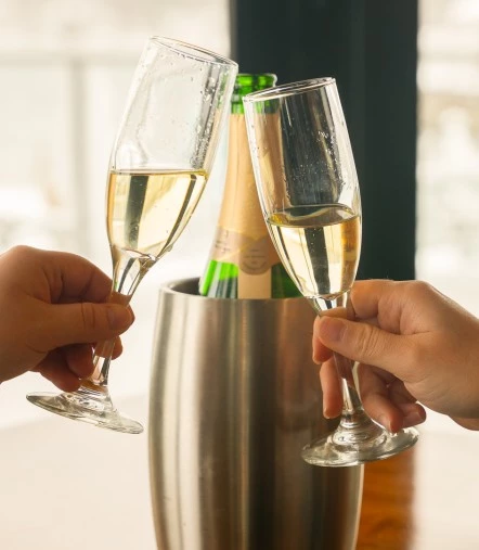 a pair of hands holding champagne glasses