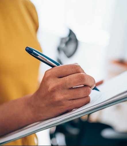 a person holding a pen and paper