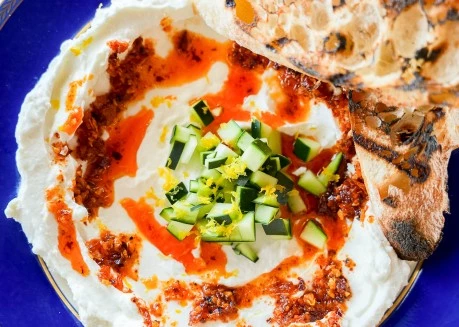 a plate of food with a tortilla and cucumber