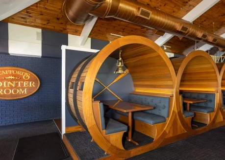 a wooden barrel shaped booth with a table and a round table