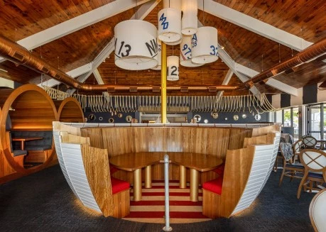 a round table with red and white chairs and a red and white striped rug