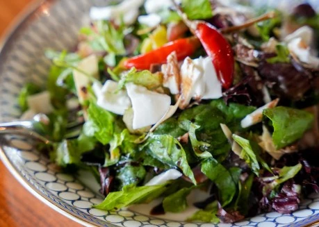 a salad with red peppers and cheese