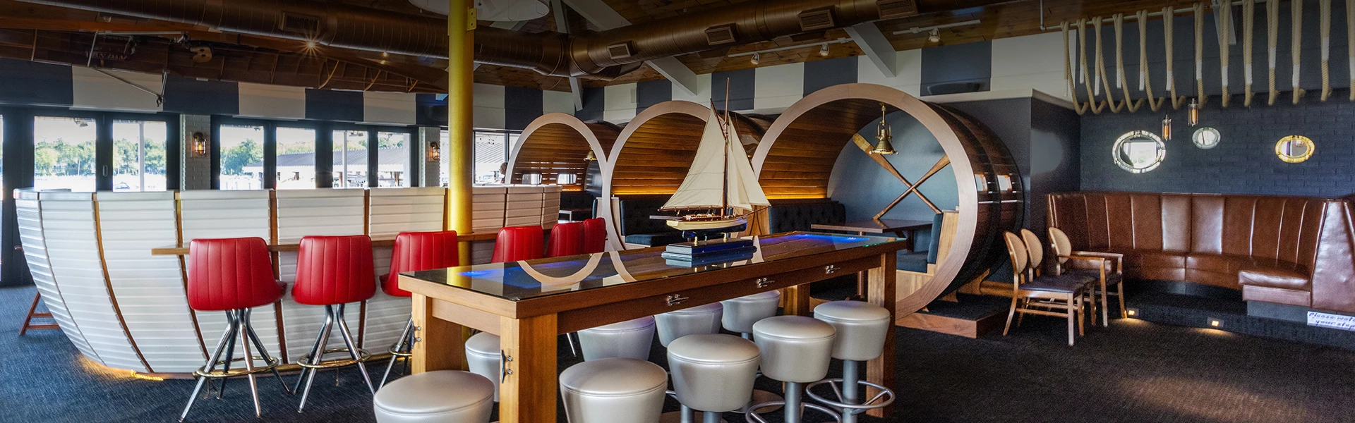 a model sailboat on a table with stools