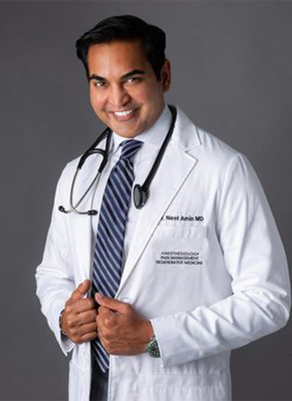 a man in a white coat with a stethoscope around his neck