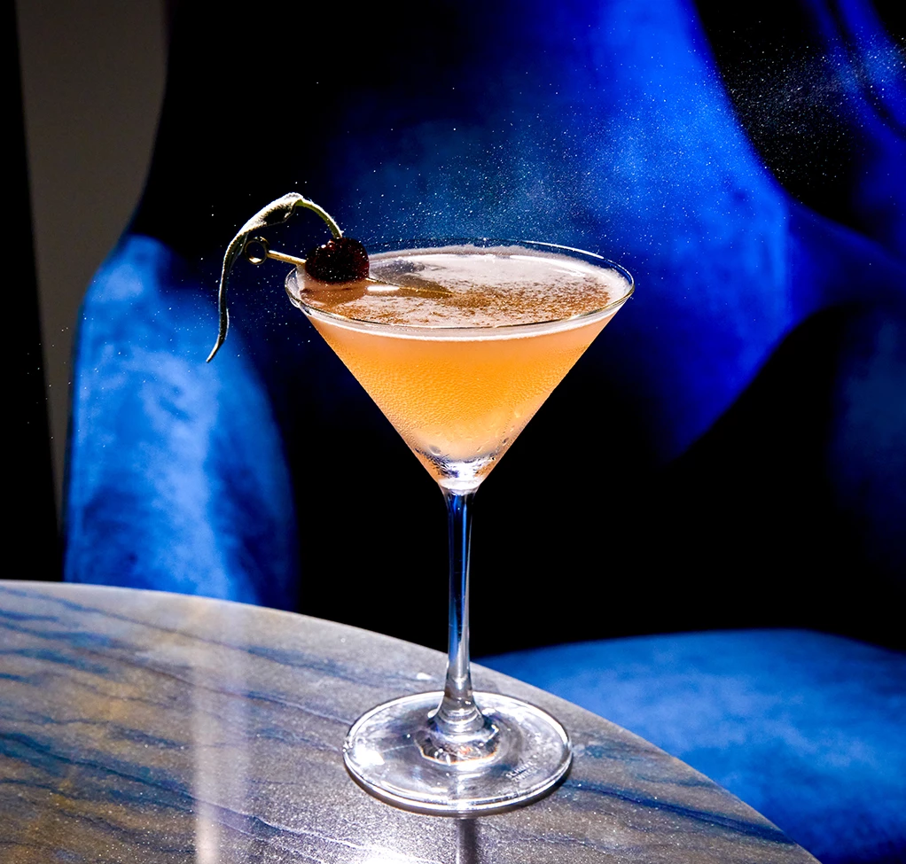 a glass with a drink on a table