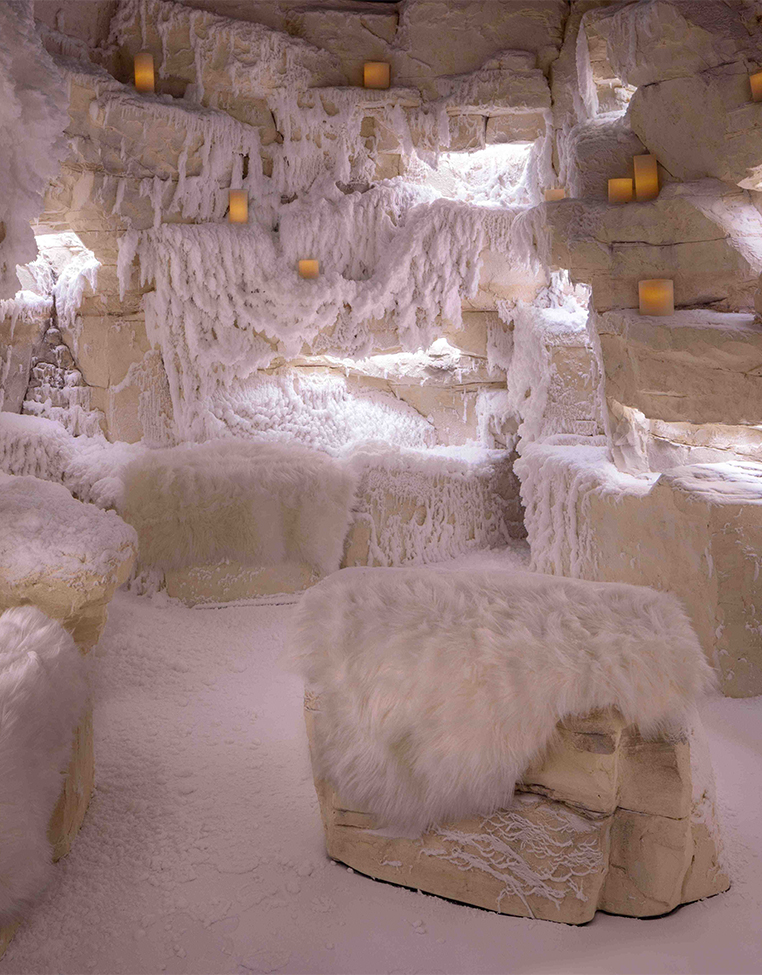 a room with snow covered rocks and candles