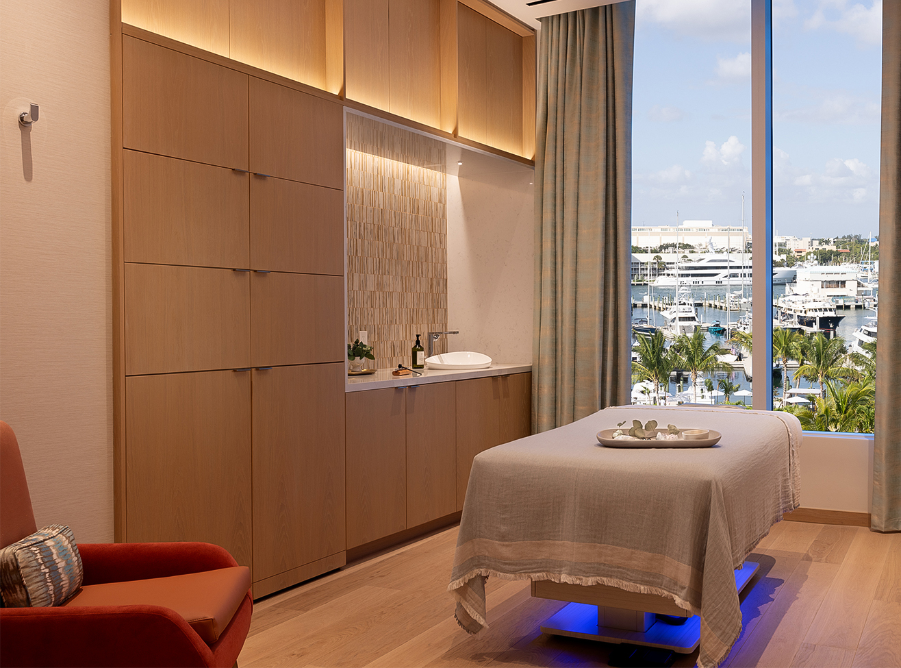 a massage table in a room with a view of the marina