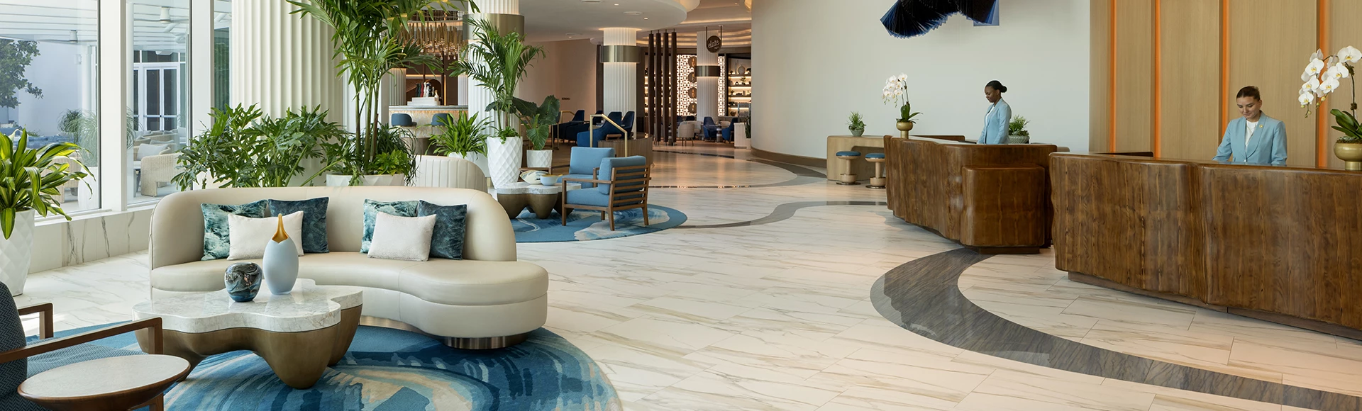 a lobby with a white chair and blue rug