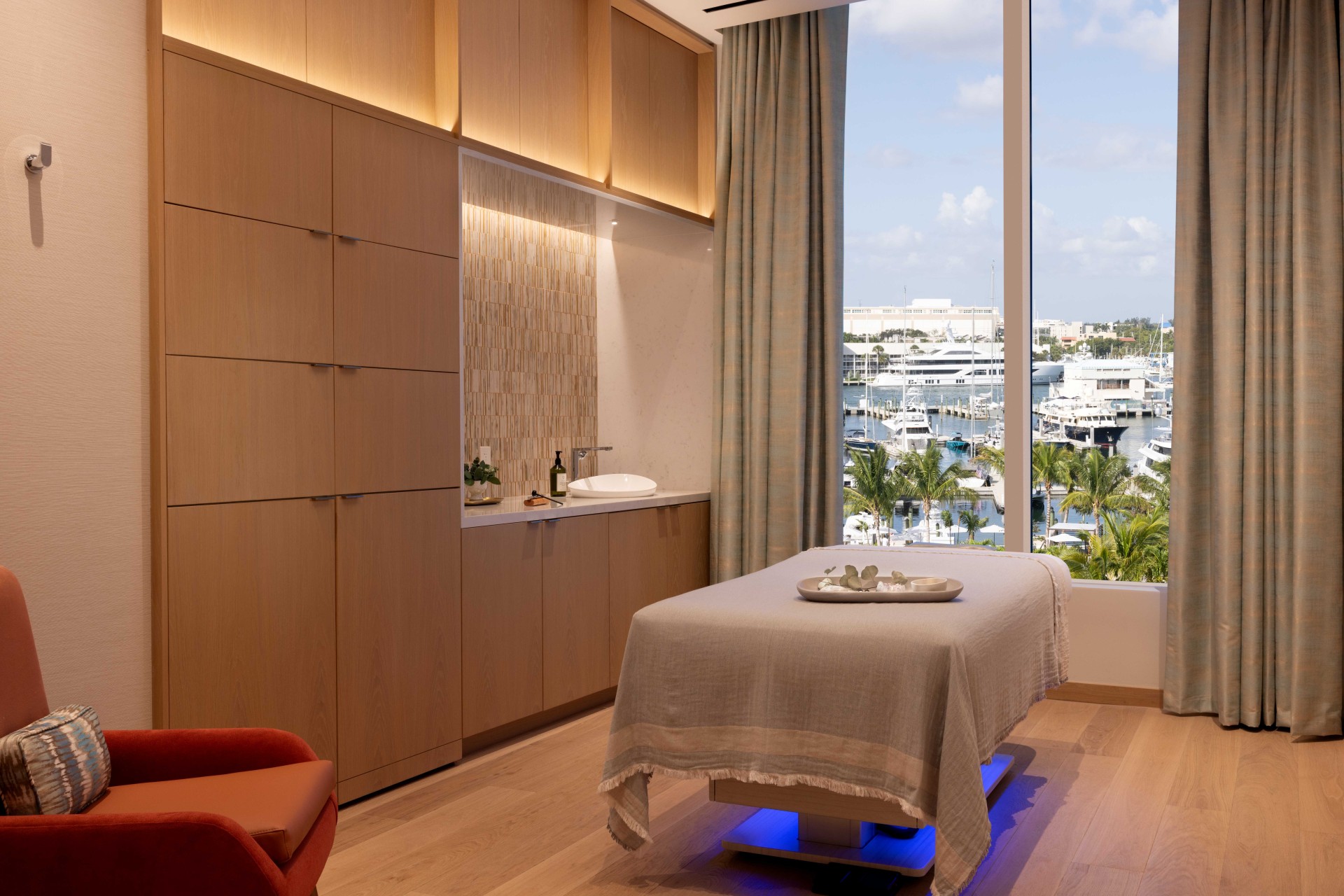 a massage table in a room with a view of marina and water