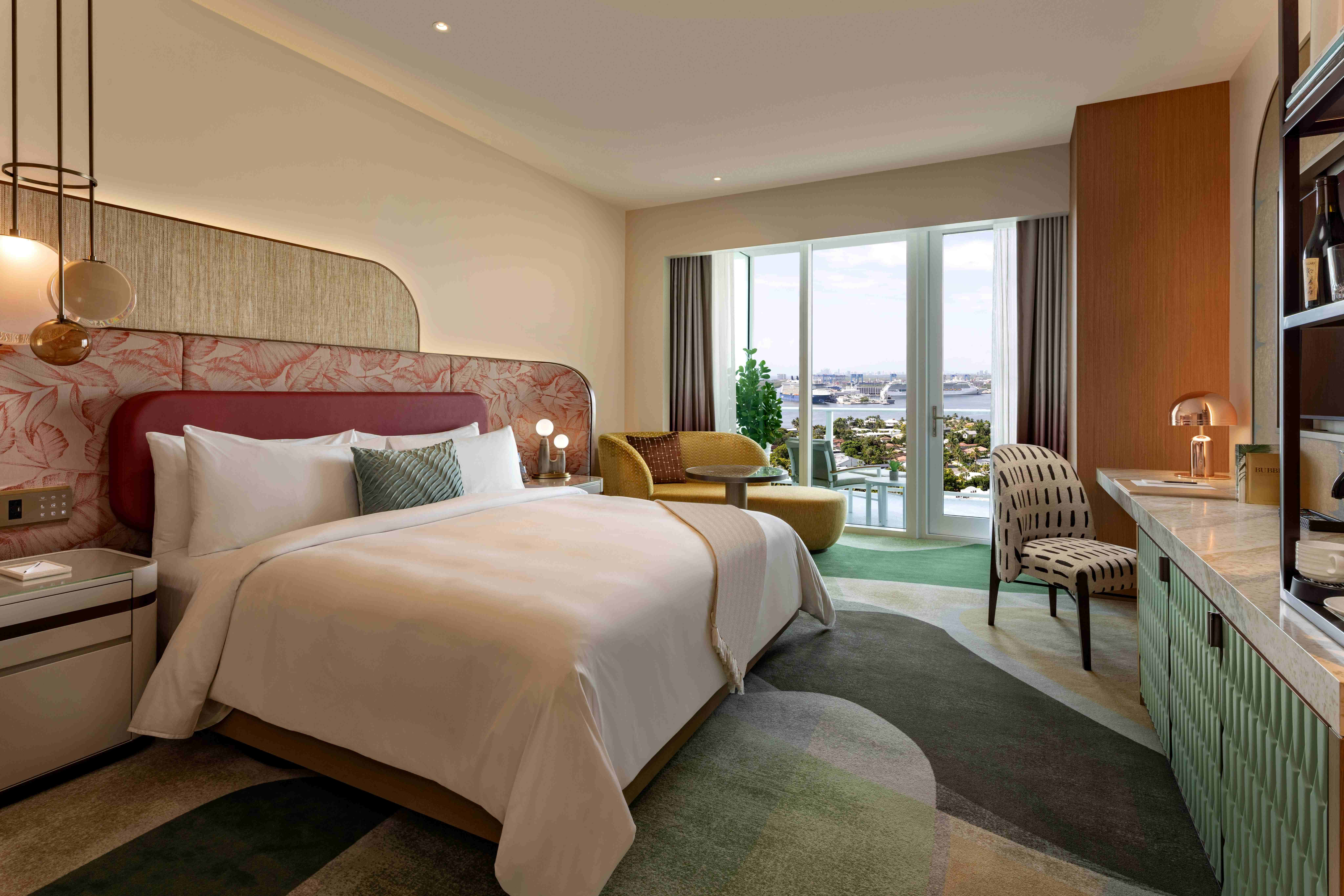 a room with a bed and chairs and a window