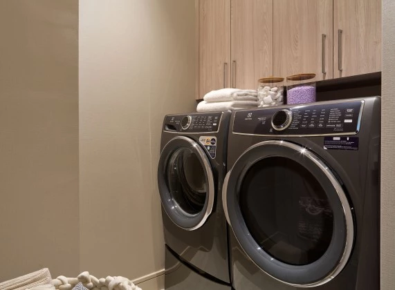 a laundry room with a washing machine and cabinets