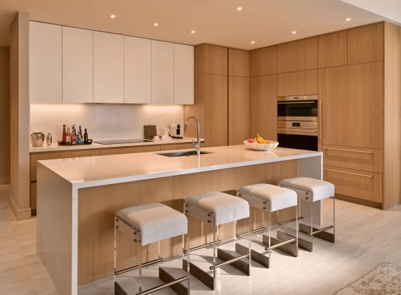 a kitchen with a white countertop and stools