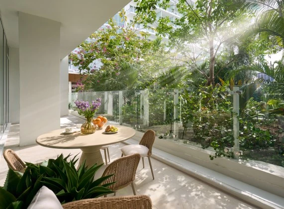 a table and chairs outside with trees and plants in the background