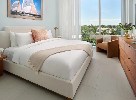 a bed in a room with a chair and a window