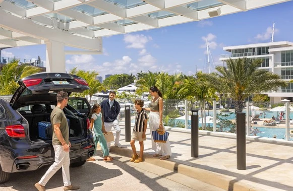a group of people standing outside of a car