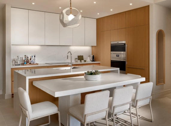 a kitchen with a white island and chairs