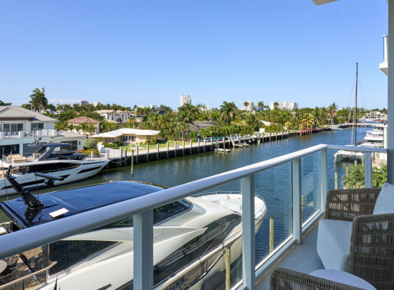 a view of a body of water from a balcony with boats and buildings