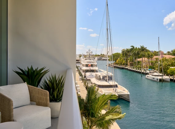 a balcony with a view of boats and palm trees