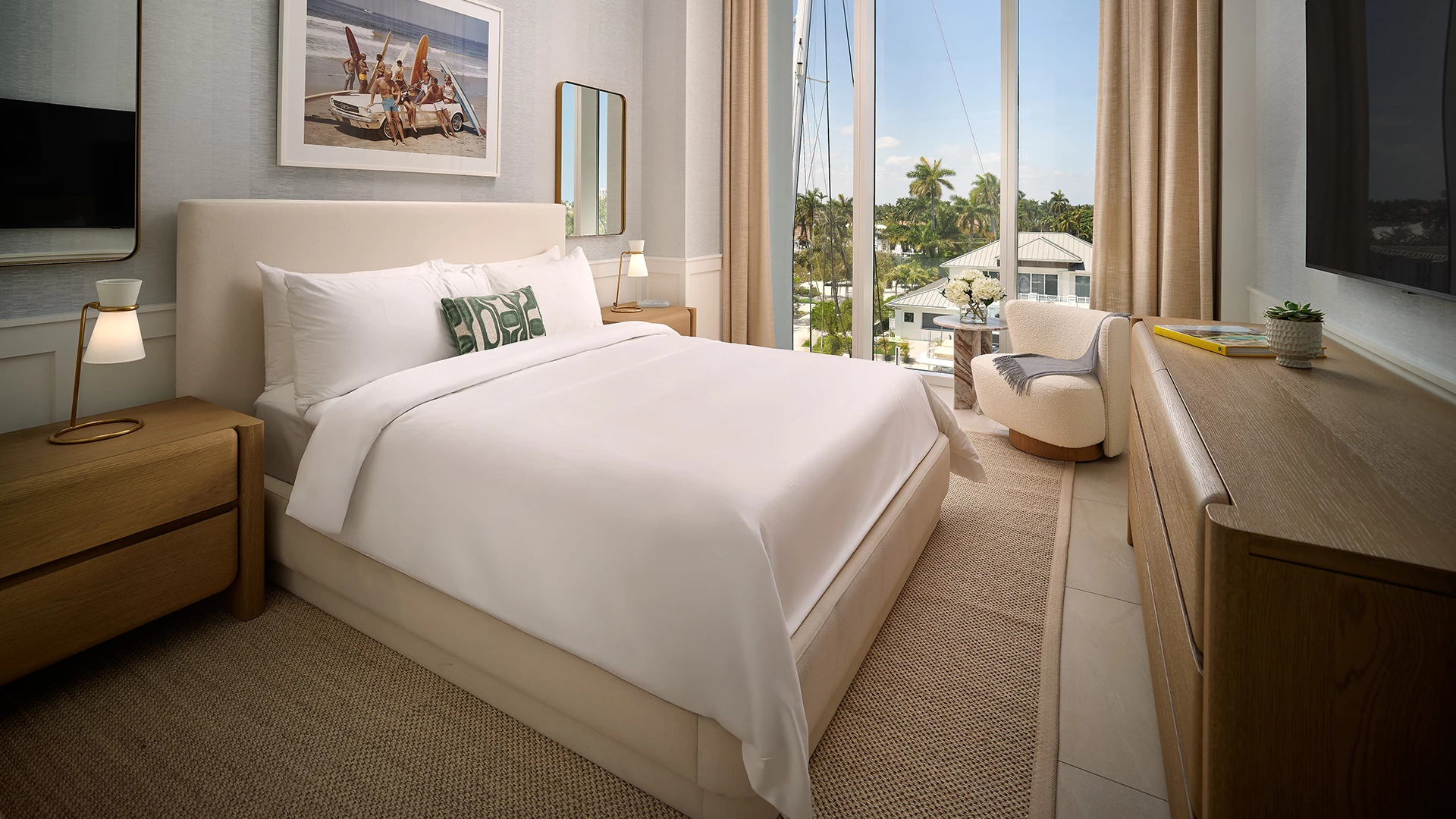 a bed with a chair and a chair in a room with a view of the ocean