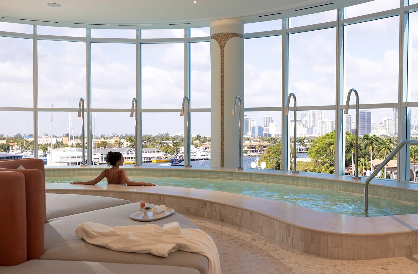 a woman in a pool with large windows