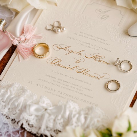 a wedding invitation with rings and perfume