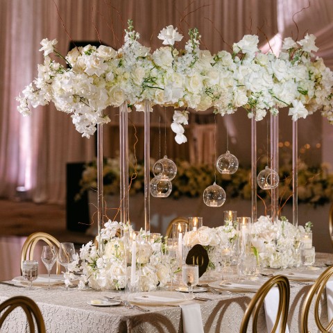 a table set with white flowers and candles