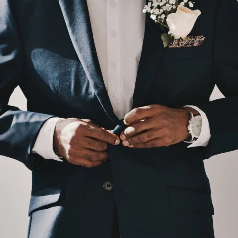 groom buttoning his suit together