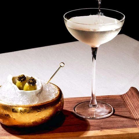 a glass of liquid pouring into a bowl of food