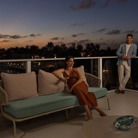 a woman sitting on a couch with a man standing behind her