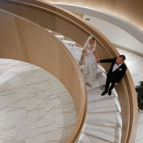 a man and woman walking down a spiral staircase