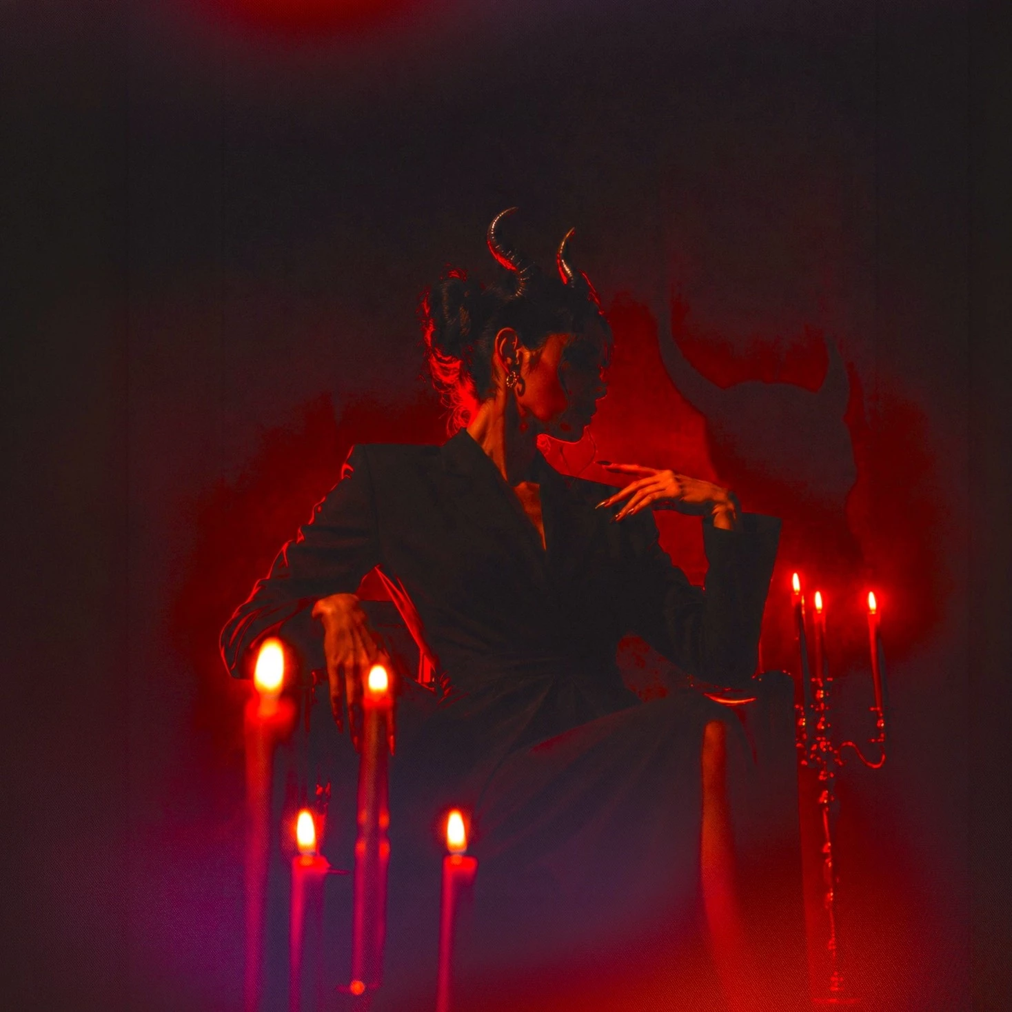 a woman sitting in a chair with horns on her head