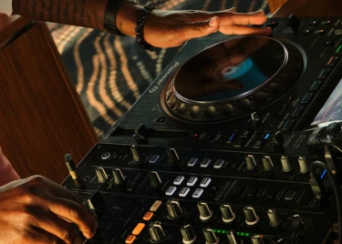 a person's hands on a dj mixer