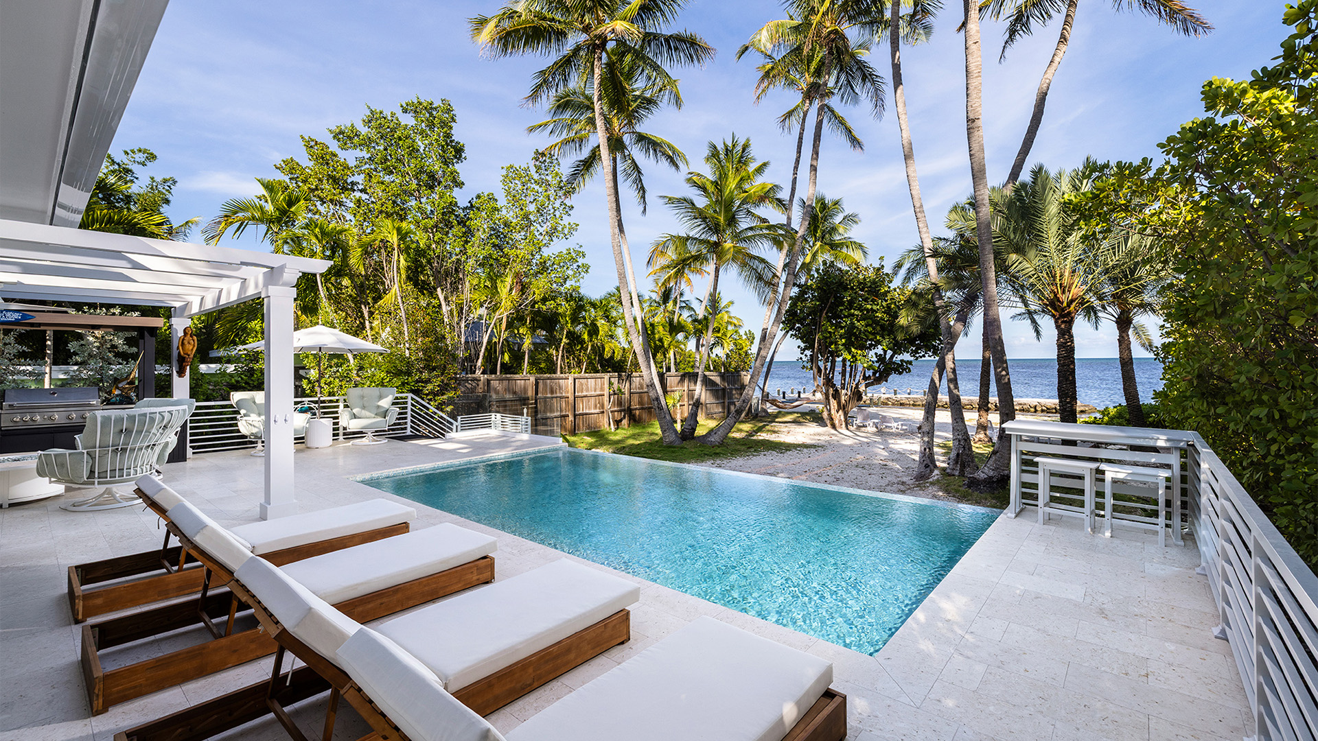 a pool with chairs and trees around it