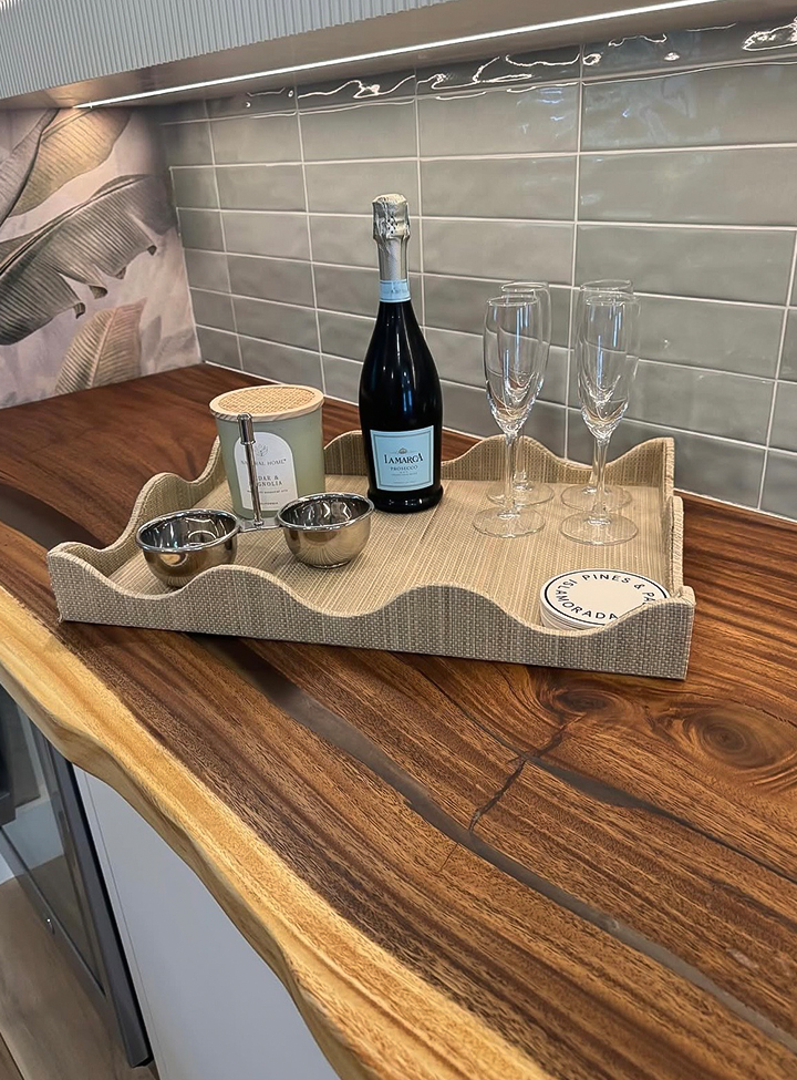 a tray with wine bottle and glasses on a counter