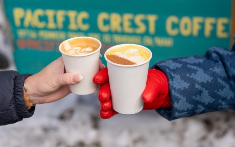 two hands holding cups of coffee