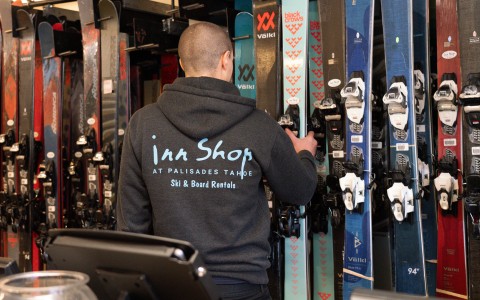 a man in a black sweatshirt looking at skis