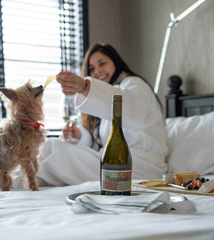 a woman in a white robe feeding a dog