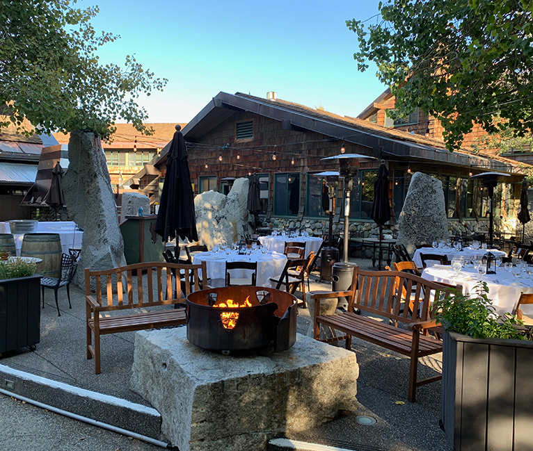 a outdoor restaurant with tables and chairs and a fire pit