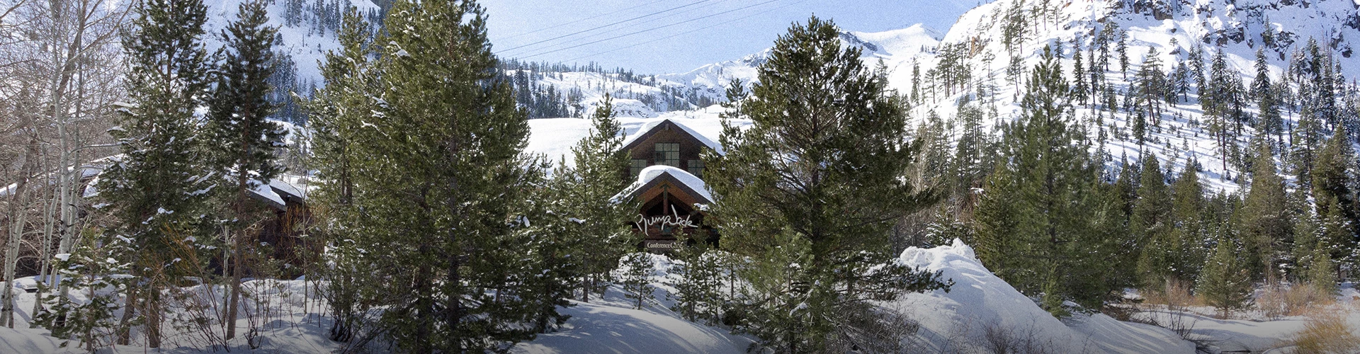 over-looking view of the Plumpjack inn entrance from a high angle during the winter season, surrounded by trees and mountains