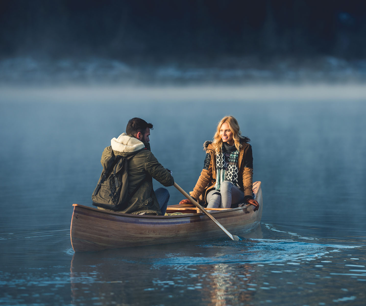 a man and woman in a canoe on a lake