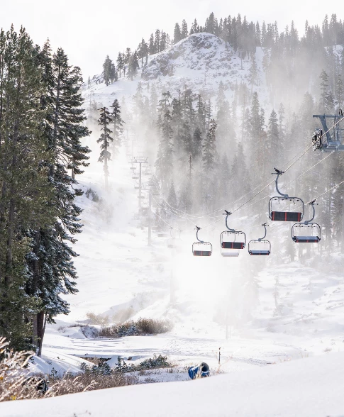 View of a ski lift during the winter with a snowy mountain in the background 