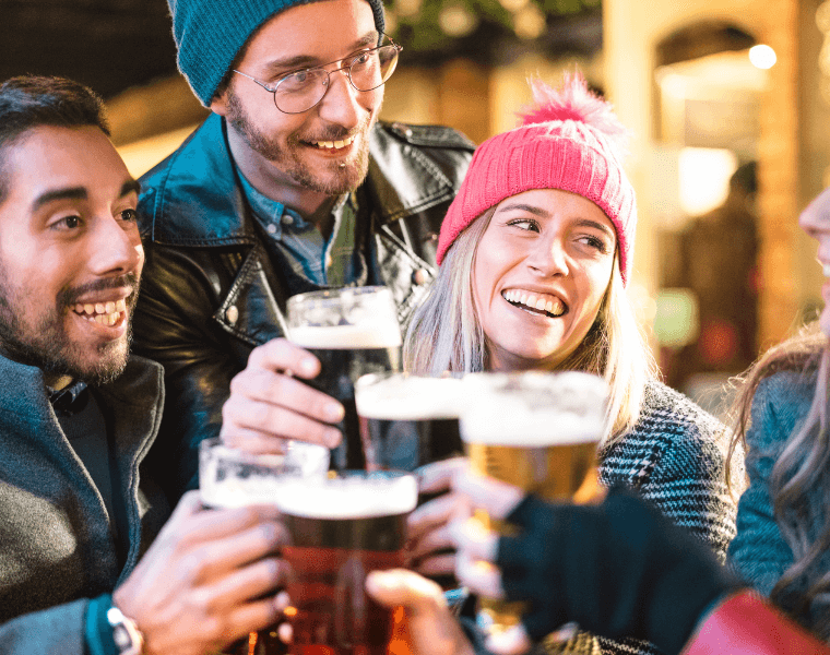 Group of friends drinking beer together during the winter